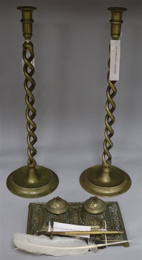 A pair of brass open twist candlesticks and an embossed brass inkwell